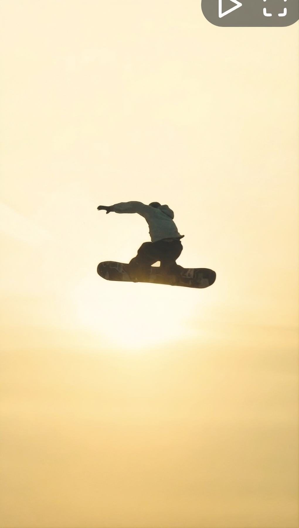 Snowboarder silhouette mid-air at sunset