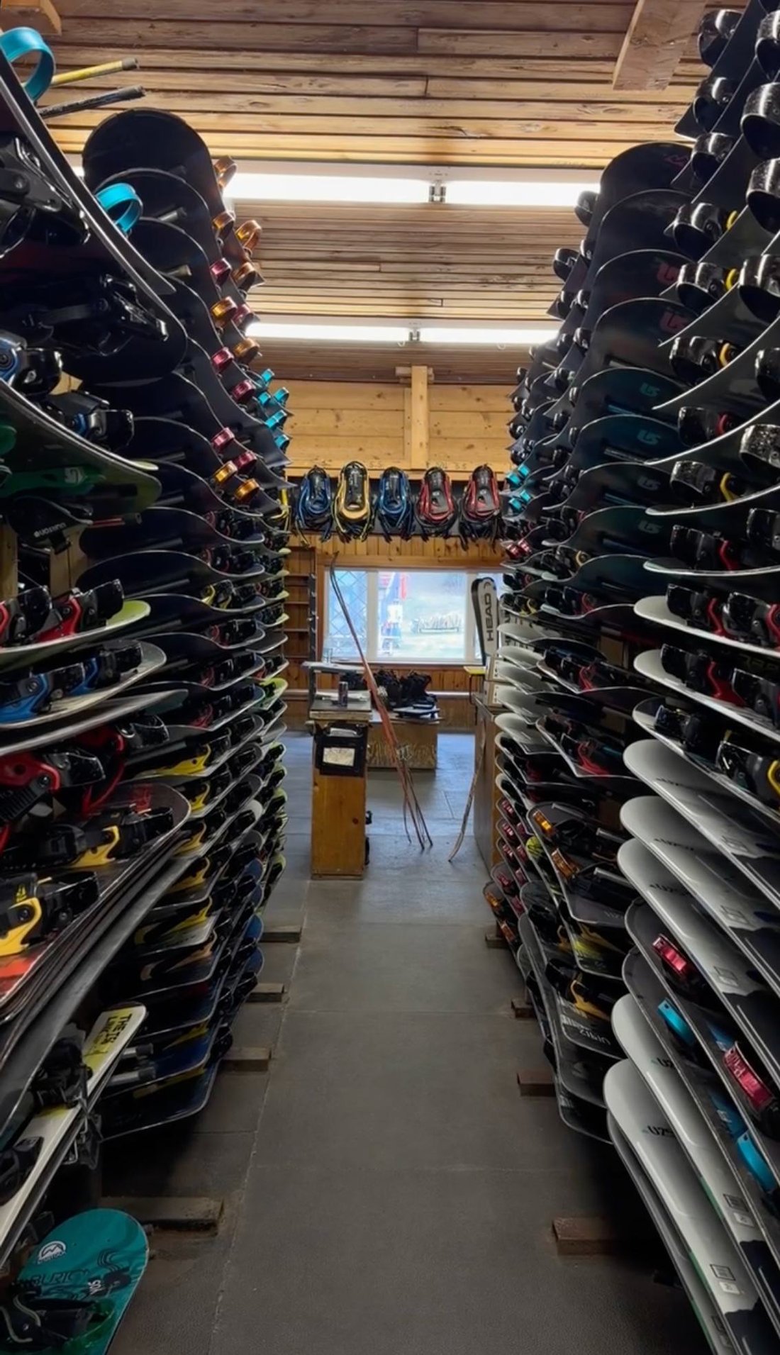 Rows of rental skis and snowboards in the Martock rental shop