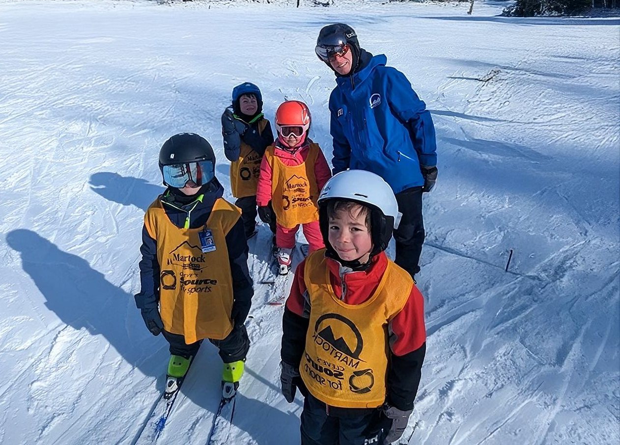 Young skiers in Martock bibs with their instructor